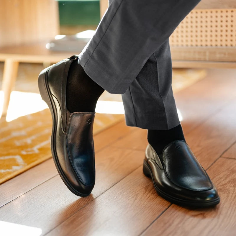 close up detail photos of Amberjack Dress Socks in Obsidian paired with The Slip-On Obsidian and gray dress pants