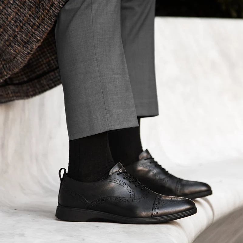 The Cap-Toe in Obsidian Black worn by model in gray pants