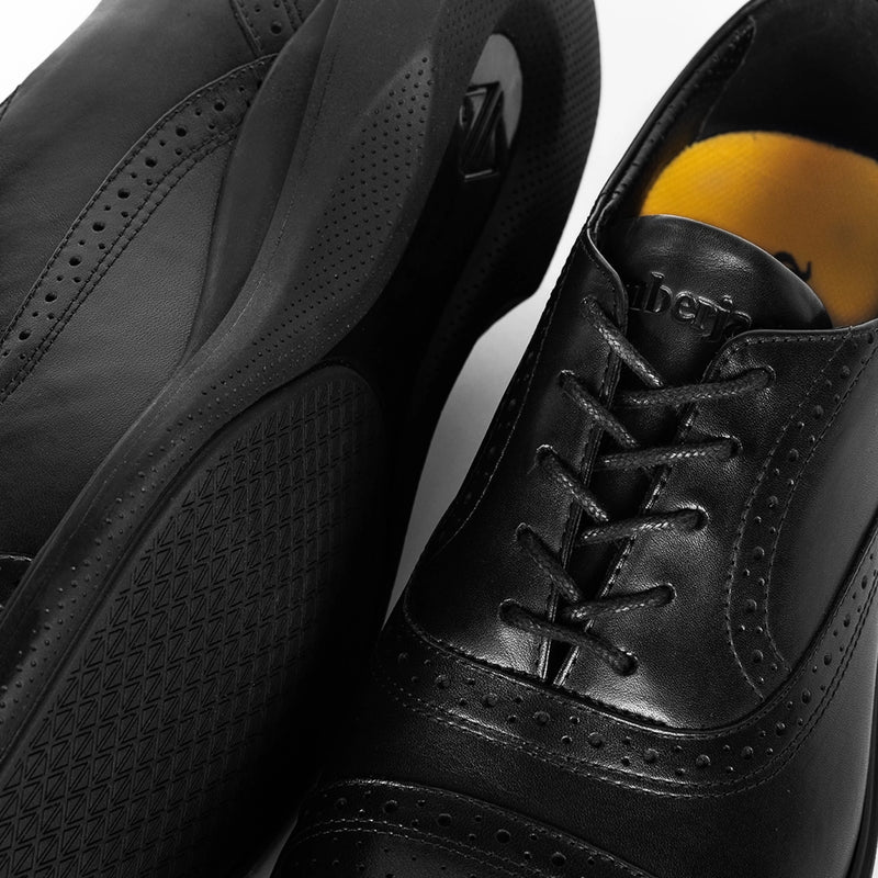 Detail photo of The Cap-Toe in Obsidian Black Leather showing broguing and laces