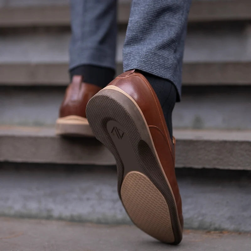 The Slip-On by Amberjack in Chestnut Brown Leather - Worn with Dark Blue Dress Pants