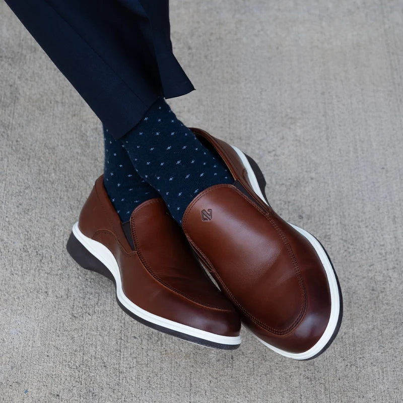 Close up photo of model wearing The Slip-On in Coffee paired with dark blue spotted dress socks